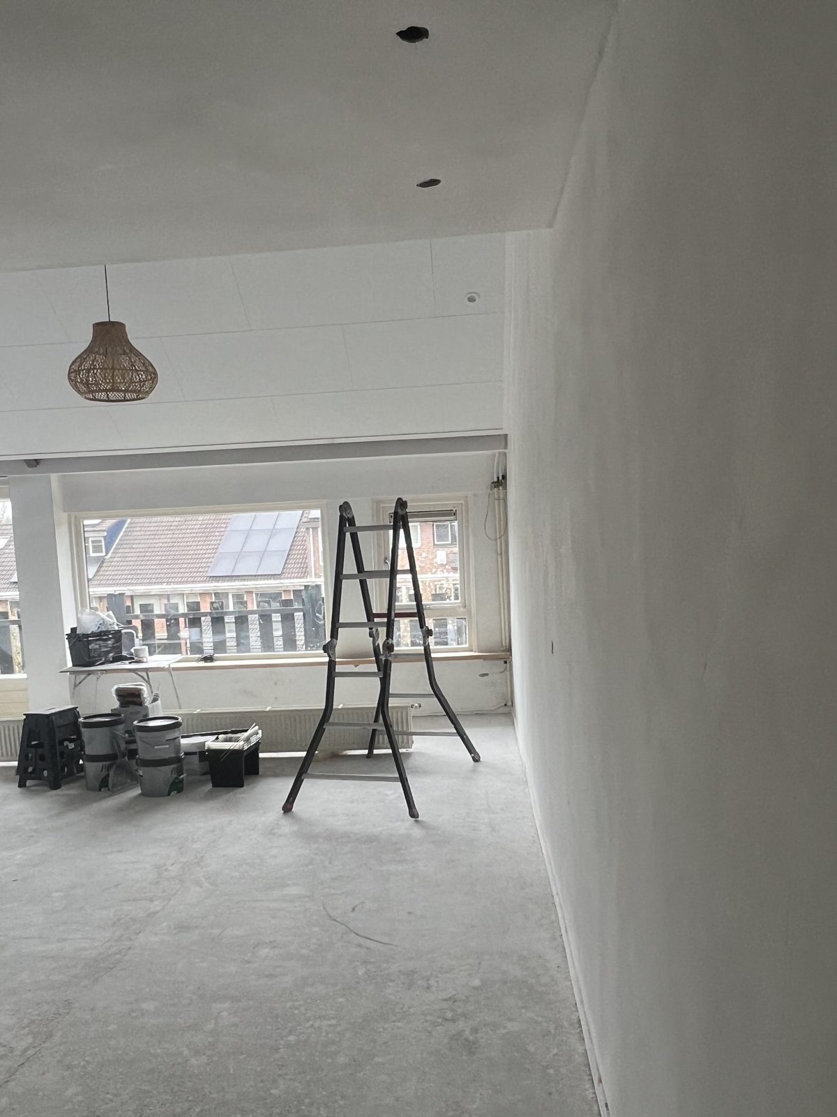 Gestuukte zolderkamer met ramen en een ladder